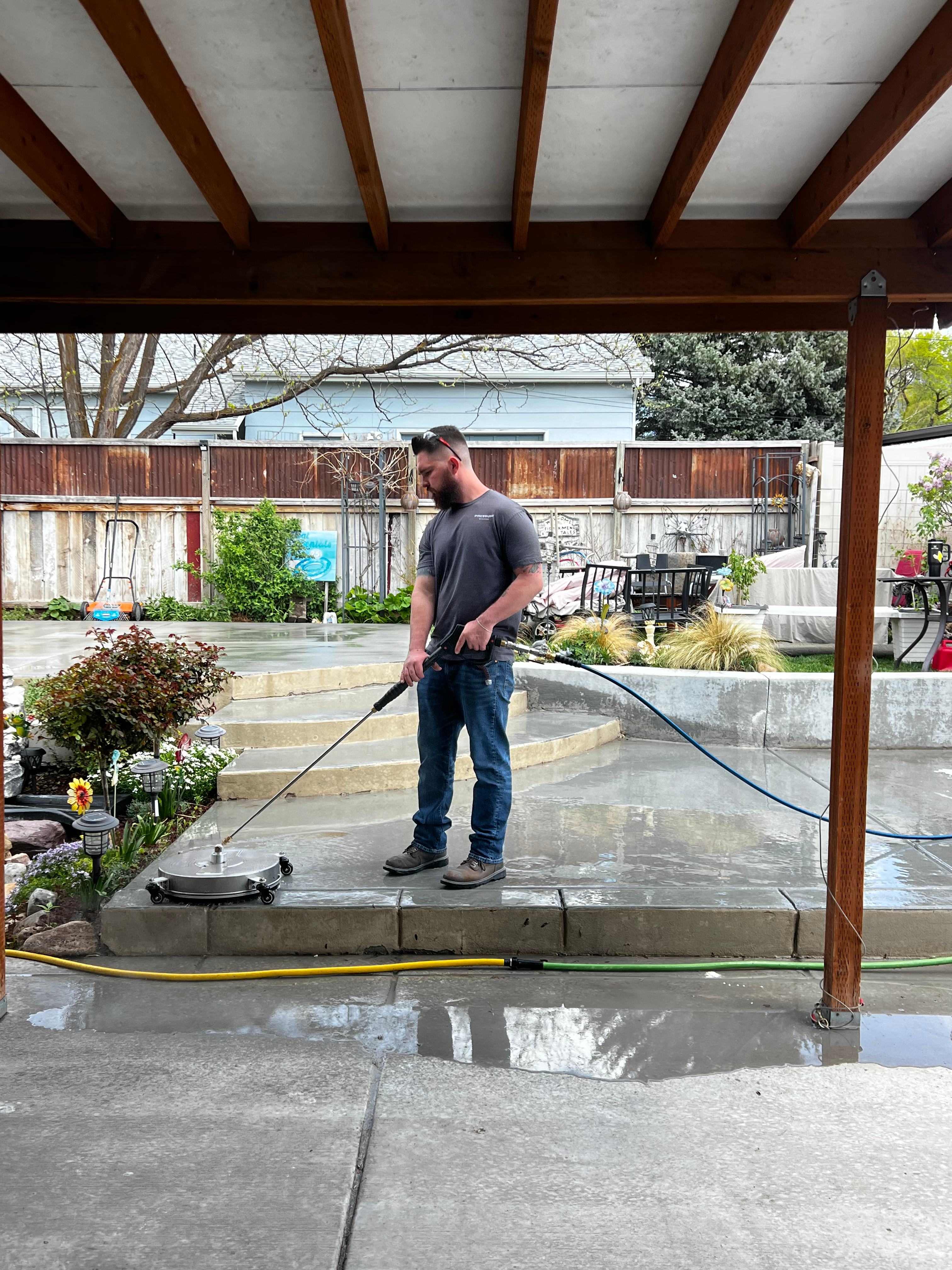 John Pollock, co-founder of Bros with Hose, pressure washing a patio